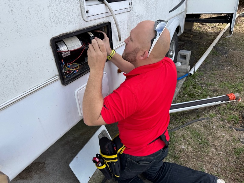 Nick performing electrical panel repair on an RV water heater